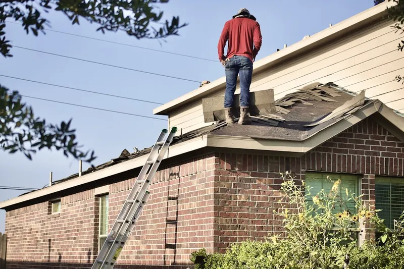Professional roofer working on a residential roof in White Center